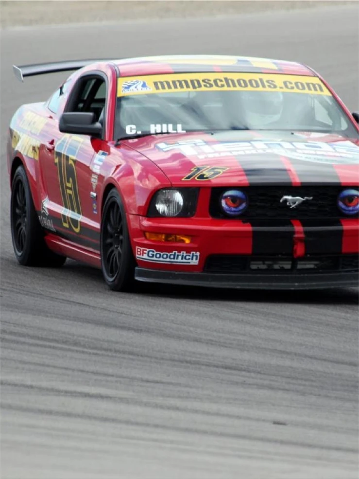Red Mustang race car number 16 with black stripes on track