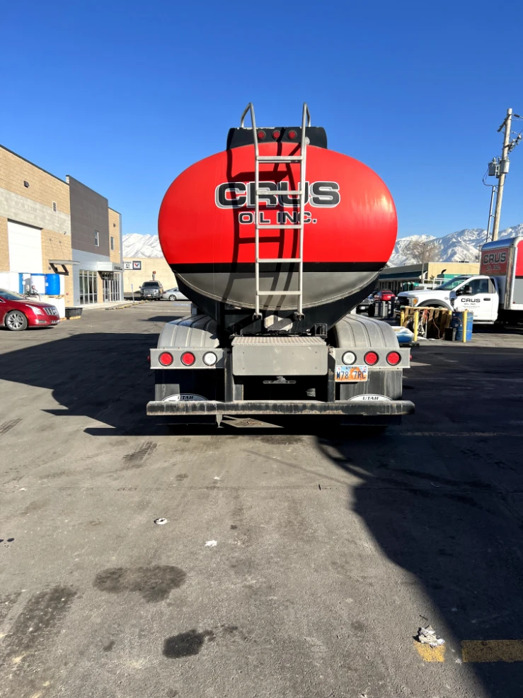 Rear view of a Crus Oil, Inc. tanker with red and black graphics