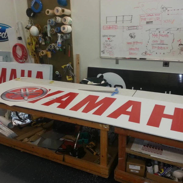 A Yamaha banner being produced on the work table inside the Falcon Graphics shop